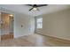 This bedroom features a ceiling fan, paneled walls, a light wood floor, and a bright window at 4131 Carroll St, Covington, GA 30014