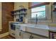 Close-up of a farmhouse sink with open shelving, adding functional storage to the kitchen at 5143 Floyd St, Covington, GA 30014