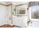 Bathroom featuring a soaking tub, large mirror, and white cabinetry at 5936 Millstone Ln, Stone Mountain, GA 30087