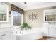 This serene bathroom features a soaking tub with a decorative window and modern fixtures at 5936 Millstone Ln, Stone Mountain, GA 30087