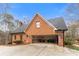 Brick home featuring an attached garage, lush landscaping, and a well-maintained yard at 5936 Millstone Ln, Stone Mountain, GA 30087