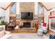 Cozy living room with stone fireplace, wood floors, vaulted ceilings, and plenty of natural light at 5936 Millstone Ln, Stone Mountain, GA 30087