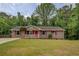 Charming single-story home featuring a landscaped lawn and a welcoming front porch with red door and shutters at 170 Hidden Pines Dr, Covington, GA 30016