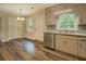 Kitchen and dining area with stainless steel dishwasher, granite countertops and wood-look flooring at 170 Hidden Pines Dr, Covington, GA 30016