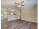 Open living room with wood-look flooring, ceiling fan, and view into the kitchen through a pass-through window at 170 Hidden Pines Dr, Covington, GA 30016