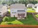 Aerial view of the backyard with a covered deck, walkout basement, and fenced yard at 1730 Dahlia Dr, Cumming, GA 30040