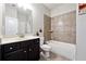 Neutral bathroom includes a single sink vanity, toilet, and shower-tub combo with tile surround at 1730 Dahlia Dr, Cumming, GA 30040