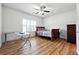 Bright bedroom featuring a ceiling fan, hardwood floors, and a modern desk and bed at 1730 Dahlia Dr, Cumming, GA 30040