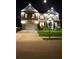 Elegant two-story home illuminated at night, showcasing a manicured lawn and charming architectural details at 1730 Dahlia Dr, Cumming, GA 30040