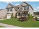 Beautiful two-story home with a well-maintained lawn, stone details, and a welcoming front porch at 1730 Dahlia Dr, Cumming, GA 30040