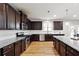 Spacious kitchen showcases dark cabinets, stainless steel appliances, granite countertops, and wood flooring at 1730 Dahlia Dr, Cumming, GA 30040