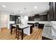 Well-lit kitchen features dark cabinetry, stainless steel appliances, granite countertops, and a kitchen island with barstool seating at 1730 Dahlia Dr, Cumming, GA 30040