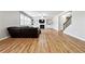 Open living room with a dark leather sofa, fireplace, built-in shelving, and wood flooring at 1730 Dahlia Dr, Cumming, GA 30040