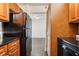 Cozy kitchen features wood cabinets and black appliances, with view into another room at 2479 Peachtree Ne Rd # 1703, Atlanta, GA 30305