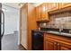 Updated kitchen features wooden cabinets, black appliances, and a mosaic tile backsplash at 2479 Peachtree Ne Rd # 1703, Atlanta, GA 30305