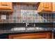 Close-up of a stainless steel sink and stylish faucet set against a decorative backsplash and granite countertop at 2479 Peachtree Ne Rd # 1703, Atlanta, GA 30305