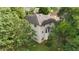 Rear aerial view highlighting the siding, bay window, and partial green space of this home at 6057 Glencedar Ln, Atlanta, GA 30349