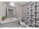 Bright bathroom features a white vanity, large mirror, and a shower with a decorative black-and-white curtain at 6057 Glencedar Ln, Atlanta, GA 30349