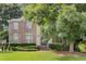 Charming brick home featuring a well-manicured lawn, mature trees, and a welcoming entrance at 6057 Glencedar Ln, Atlanta, GA 30349