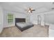 Carpeted main bedroom featuring a tray ceiling, ceiling fan, and large windows at 6057 Glencedar Ln, Atlanta, GA 30349