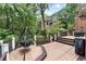 Large deck with grill and outdoor oven in a lush, wooded backyard at 6185 Masters Club Dr, Suwanee, GA 30024