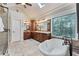 Beautiful bathroom featuring a freestanding tub, granite counters, skylight and decorative stained-glass window at 6185 Masters Club Dr, Suwanee, GA 30024