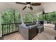 Covered deck with ample seating and views of a lush, wooded backyard at 6185 Masters Club Dr, Suwanee, GA 30024