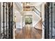 Grand foyer with hardwood floors, staircase, and ornate iron door and hardware at 6185 Masters Club Dr, Suwanee, GA 30024