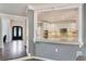 View of a traditional kitchen with white cabinets and granite countertops, as seen through a decorative opening at 6185 Masters Club Dr, Suwanee, GA 30024