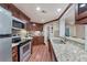 Charming kitchen featuring granite countertops, stainless steel appliances, and wood cabinets with ample storage at 6185 Masters Club Dr, Suwanee, GA 30024