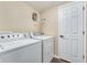 Laundry room with washer, dryer, and convenient storage shelves at 6185 Masters Club Dr, Suwanee, GA 30024