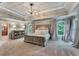 Spacious main bedroom featuring a tray ceiling, decorative chandelier, and ensuite bathroom at 6185 Masters Club Dr, Suwanee, GA 30024