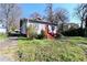 Charming home with red accents and a small porch, surrounded by greenery at 692 Moreland Se Ave, Atlanta, GA 30316