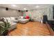 Spacious basement area with a large sectional, stone wall, and hardwood flooring creates a cozy ambiance at 1164 Bonview Ne Ln, Atlanta, GA 30324