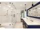 Bright bathroom featuring double vanity with blue cabinets, a large glass shower, and neutral white tiling at 1164 Bonview Ne Ln, Atlanta, GA 30324