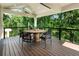 Beautiful outdoor deck with modern black chairs, round table, and natural wood flooring surrounded by lush greenery at 1164 Bonview Ne Ln, Atlanta, GA 30324