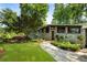 Charming stone-faced home with manicured lawn, stone walkway, mature trees, and decorative shrubbery at 1164 Bonview Ne Ln, Atlanta, GA 30324