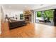 Open living room with stone fireplace, leather sofa, and sliding doors to an outdoor lounge at 1164 Bonview Ne Ln, Atlanta, GA 30324