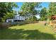Large grass backyard surrounded by a wooden privacy fence, green trees, landscaped garden and a deck at 1967 Cogar Dr, Decatur, GA 30032