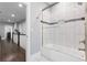 Bathroom boasts large tiles, a glass door bathtub, and a view to the hall at 1967 Cogar Dr, Decatur, GA 30032