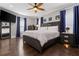 Spacious bedroom features hardwood floors, modern ceiling fan, and beautiful blue curtains at 1967 Cogar Dr, Decatur, GA 30032