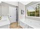 Bright bathroom featuring a soaking tub, a shower, double vanity sinks, and wood-look flooring at 2720 Meridian Ct, Dacula, GA 30019