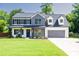 Charming two-story home with black shutters, gray brick, a manicured lawn and an attached garage at 2720 Meridian Ct, Dacula, GA 30019