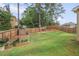 Large backyard with a wooden fence, garden area, and ample green space for activities at 3586 Maple Hill Rd, Stonecrest, GA 30038