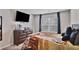 Bedroom featuring tv, neutral carpet, blinds, dresser, neutral walls and tiger themed comforter at 3586 Maple Hill Rd, Stonecrest, GA 30038