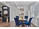 Stylish dining room featuring a glass table, blue velvet chairs, and modern chandelier at 3586 Maple Hill Rd, Stonecrest, GA 30038