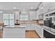 Bright, white kitchen featuring an island, stainless steel appliances, and granite countertops at 3586 Maple Hill Rd, Stonecrest, GA 30038