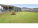 Spacious backyard with lush green grass, a fire pit, and a covered patio area at 3026 Towne Mill Ave, Canton, GA 30114