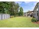 Green backyard featuring a storage shed, flowerbeds and a covered porch at 3026 Towne Mill Ave, Canton, GA 30114