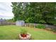 Lush backyard featuring a storage shed, a fire pit, and mature trees at 3026 Towne Mill Ave, Canton, GA 30114